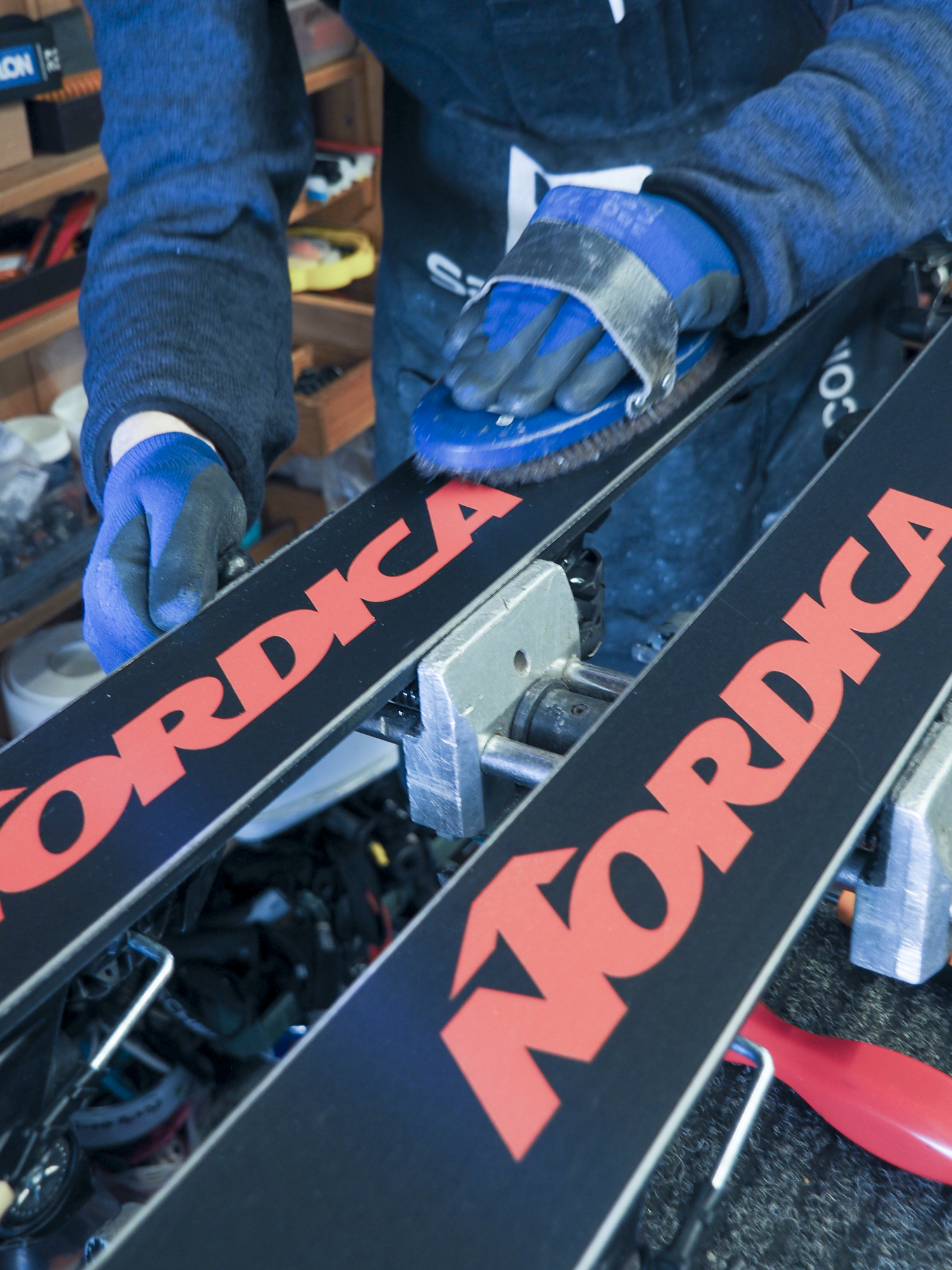 Technician brushing the base of skis